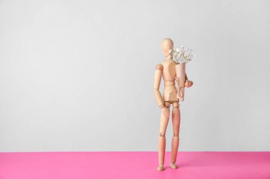 Hafif arka planda buketi olan tahta manken. Anneler Günü kavramı