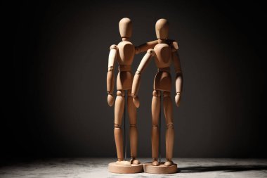 Karanlık arka planda tahta mankenler. Arkadaşlık kavramı