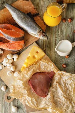 Ahşap arka planda D vitamini içeren farklı ürünler