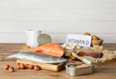 Metin VITAMIN D ve ahşap zemin üzerinde farklı sağlıklı ürünler