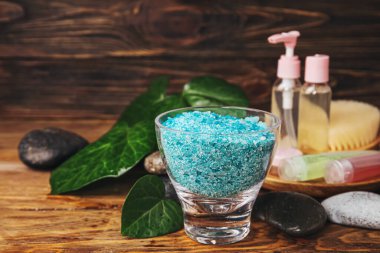 Ahşap zemin üzerinde deniz tuzu ve kozmetik ürünleri olan güzel bir spa kompozisyonu