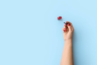 Arka planda tırnak cilası olan kadın eli