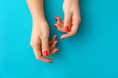 Mavi arka planda güzel manikürlü kadın elleri, yakın plan.