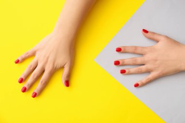 Sarı arka planda güzel manikürlü kadın elleri, yakın plan.