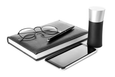 Beyaz arkaplanda şık gözlükler, parfüm, defter ve cep telefonu