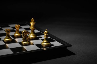Siyah arkaplanda oyun tahtası olan satranç taşları