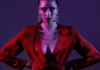 Koyu mor arka planda şık bir genç kadın.