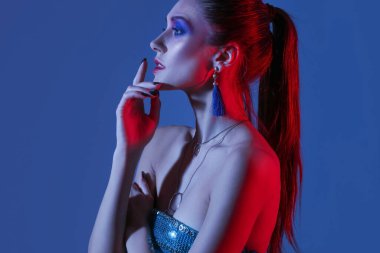 Koyu mavi arka planda şık bir genç kadın.