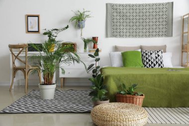 İçinde bitkiler olan şık bir yatak odası.