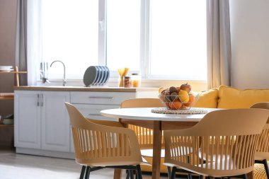 Modern mutfaktaki yemek masasında taze meyve sepeti.