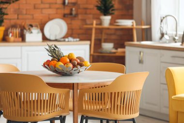 Modern mutfaktaki yemek masasında taze meyve sepeti.