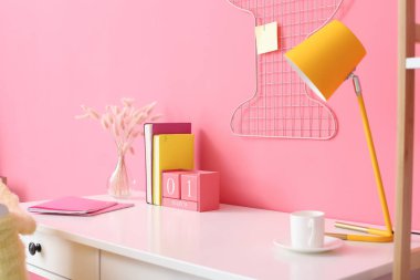 Renk duvarına yakın modern lambalı şık bir iş yeri.