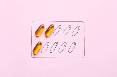 Arka planda balık yağı haplarıyla su toplamış.