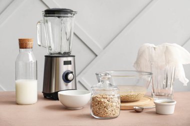 Lezzetli yulaf sütü ve mutfak masasındaki malzemelerle dolu bir şişe.