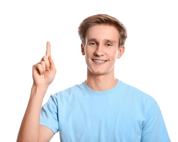 Hombre Guapo Con Frenos Dentales Mostrando Algo Sobre Fondo Blanco —  Fotos de Stock