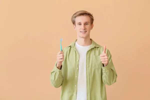 Homem Bonito Com Aparelho Dentário Escova Dentes Mostrando Gesto Polegar — Fotografia de Stock