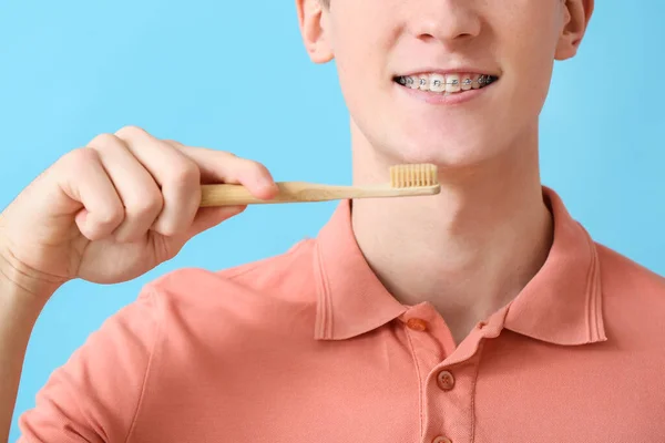 歯のブレースと歯ブラシを持つハンサムな男の背景色 クローズアップ — ストック写真