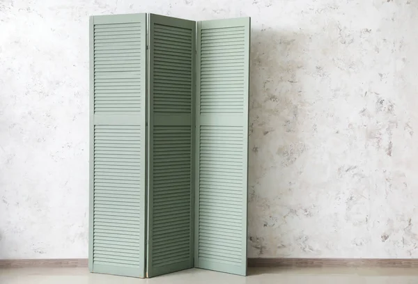 Modern green folding screen near light wall