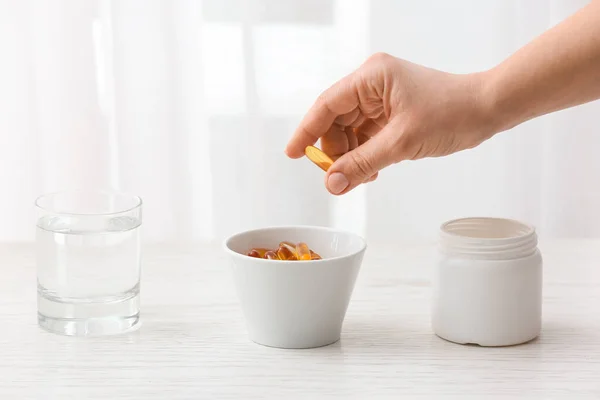 Woman Taking Fish Oil Pill Bowl Table Closeup — Stock Photo, Image