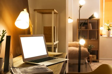 Dizüstü bilgisayarı ve parlak lambası olan modern bir iş yeri