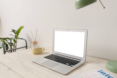 Işık duvarı yakınında dizüstü bilgisayarı ve sazlığı olan modern bir işyeri