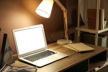 Dizüstü bilgisayarı ve parlak lambası olan modern bir iş yeri