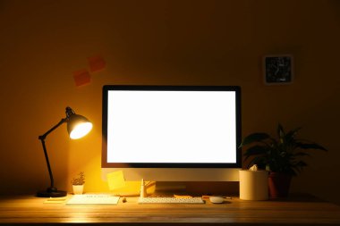 Modern bilgisayarlı ve karanlık odada parlayan lambalı işyeri