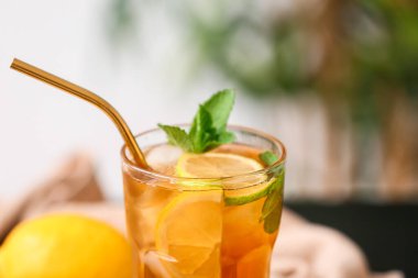 Arka planda bulanık limonlu bir bardak lezzetli buzlu çay. Yakın plan.