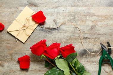 Ahşap arka planda güzel güller ve zarf