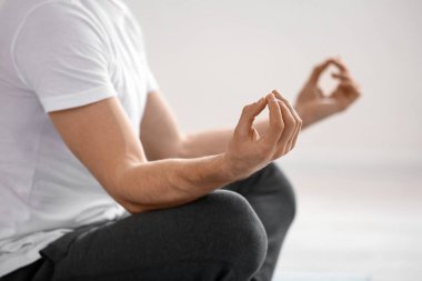 Evde yoga yapan genç bir adam, yakın çekim.