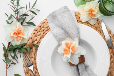 Beyaz arka planda narsis çiçekleri olan güzel bir masa.