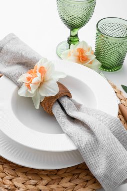 Beyaz arka planda narsis çiçekleri olan güzel bir masa.