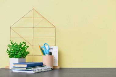 Renk duvarının yanında not defterleri ve kırtasiye malzemesi olan şık bir iş yeri