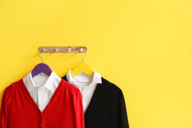 Renkli duvarda şık okul üniforması olan bir askı.