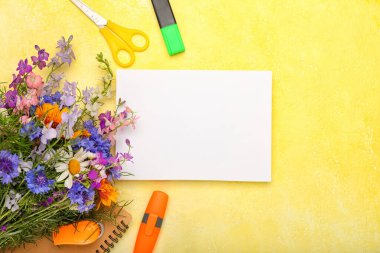 Boş bir kağıt, bir buket güzel çiçek ve renkli arka planda kırtasiye malzemesi, yakın plan. Öğretmenler Günü kutlaması