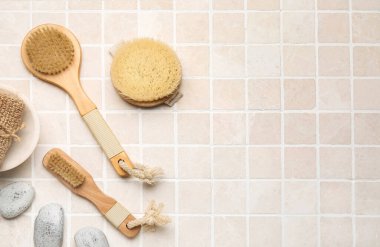 Farklı masaj fırçaları ve arka planda banyo malzemeleri.