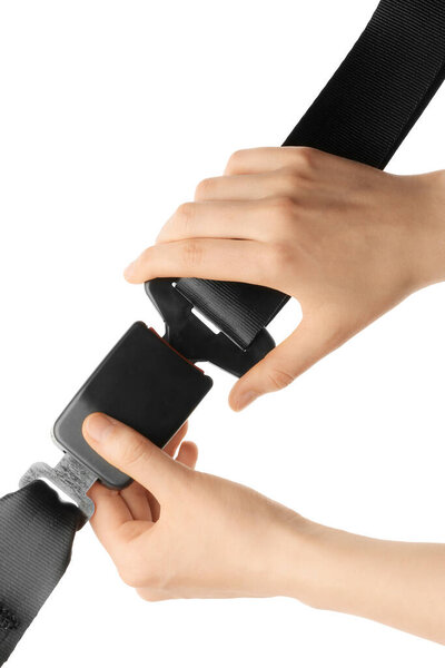 Женщина пристегивает ремень безопасности на белом фоне