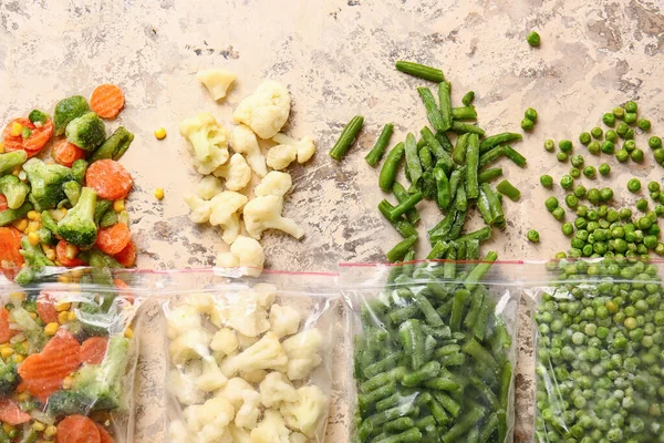 Пластикові Пакети Різними Замороженими Овочами Кольоровому Фоні — стокове фото