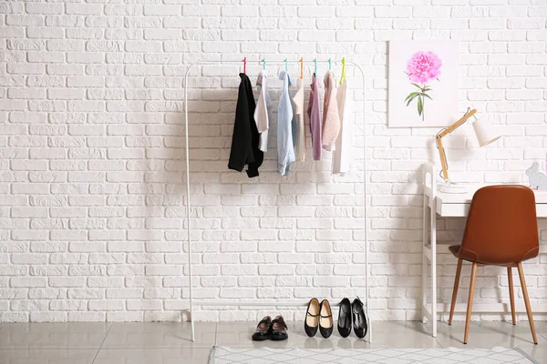 Rack with stylish school uniform in interior of room