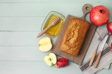 Ballı ekmek, nar ve renkli ahşap arka planda elmalar. Rosh hashanah (Yahudi Yeni Yılı) kutlaması