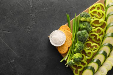 Koyu arka planda farklı yeşil sebzeleri olan ahşap tahta, yakın plan.