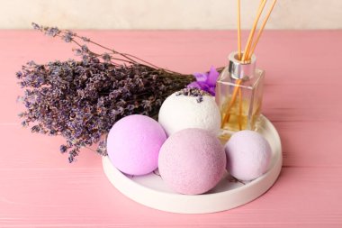 Banyo bombalı tabaklar, sazlık ayırıcı ve ahşap arkaplanda lavanta çiçekleri.