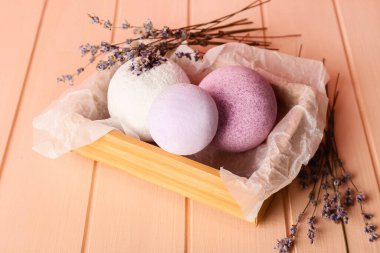 Banyo bombalarıyla dolu bir kutu ve ahşap arkaplanda lavanta çiçekleri
