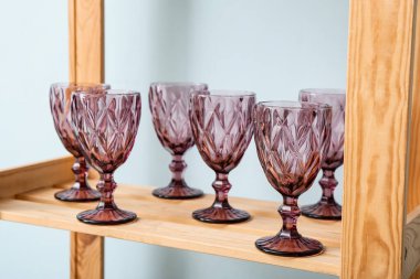 Renk duvarının yanındaki raf ünitesinde boş bardaklar