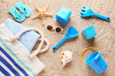 Çocuklar için plaj aksesuarları, kum üzerinde çanta ve havlu.