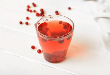 Hafif ahşap arka planda kızılcıklı bir fincan lezzetli çay.