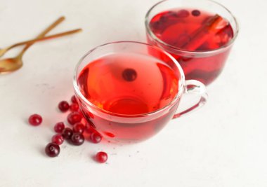 Hafif arkaplanda kızılcık olan bir fincan lezzetli çay.