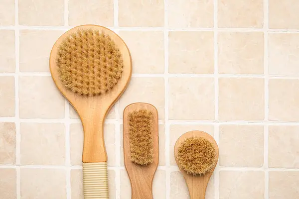 Different Massage Brushes Light Tile Background Closeup — Stock Photo, Image