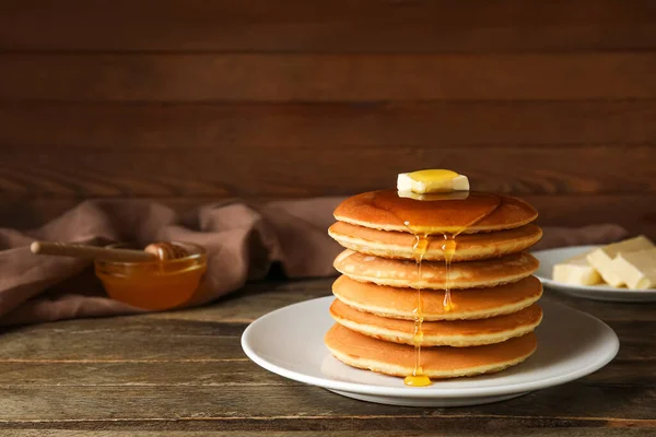 木製の背景に蜂蜜とバターとおいしいパンケーキのプレート — ストック写真