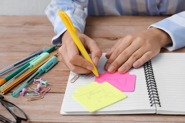 Bir kadın masadaki yapışkan nota KONUŞAN yazıyor, yakın çekim